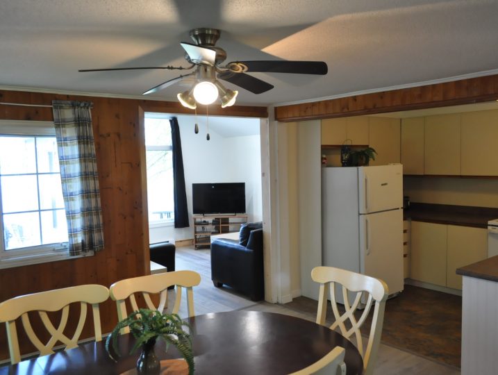 Dining space opening into living room inside The Cove 245B cottage rental near Ottawa.
