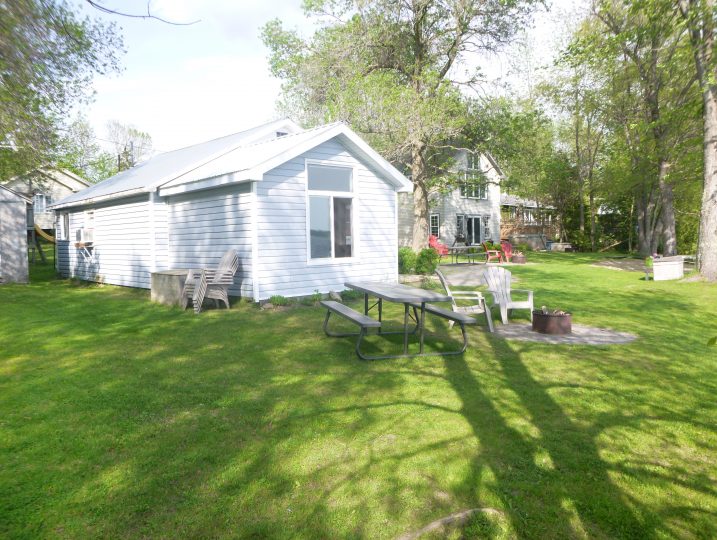 Outdoor picnic table and firepit area beside The Cove 245B cottage at White Lake.