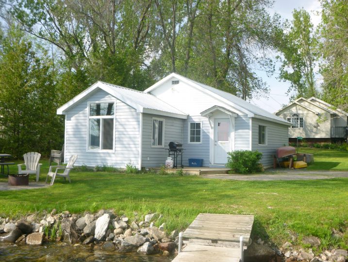 The Cove 245B waterfront cottage at White Lake near Ottawa with private dock and lakefront lawn in summer.